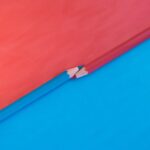 Abstract composition featuring red and blue pencils on contrasting red and blue backgrounds