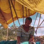 Elderly woman working under a makeshift tent in egbado south nigeria showcasing local lifestyle